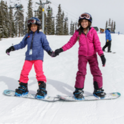 Friends holding hands while snowboarding with SOS Outreach